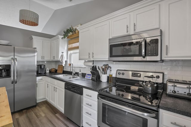 840 Gulliver Dr, Columbus, OH 43207 - kitchen with appliances with stainless steel finishes, a sink, white cabinetry, lofted ceiling, and decorative backsplash