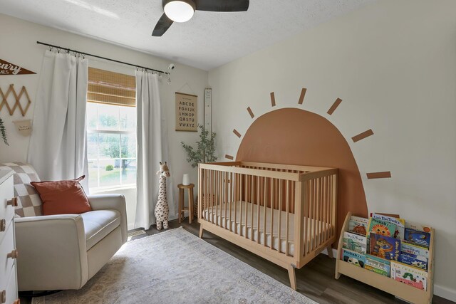 840 Gulliver Dr, Columbus, OH 43207 - bedroom featuring wood finished floors, a nursery area, a textured ceiling, and ceiling fan