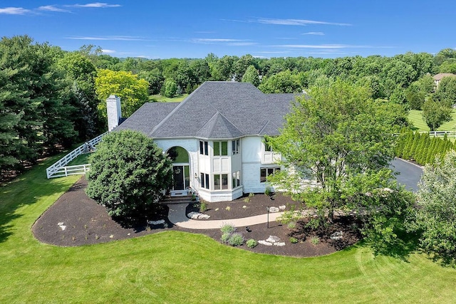 2570 Jewett Rd, Powell, OH 43065 - view of front of house with a balcony, a shingled roof, a front yard, a chimney, and stucco siding