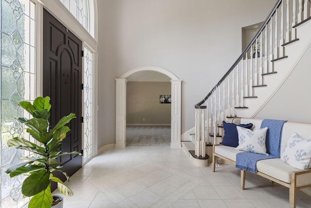2570 Jewett Rd, Powell, OH 43065 - foyer with ornate columns, a high ceiling, stairway, light tile patterned floors, and arched walkways