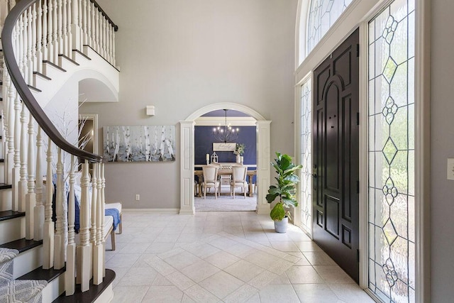 2570 Jewett Rd, Powell, OH 43065 - tiled entrance foyer with stairway, a towering ceiling, decorative columns, a chandelier, and arched walkways