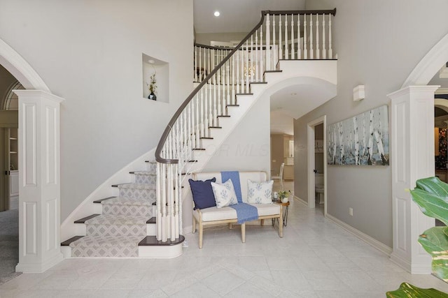 2570 Jewett Rd, Powell, OH 43065 - stairway with ornate columns, arched walkways, a towering ceiling, tile patterned floors, and recessed lighting