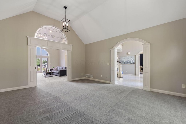 2570 Jewett Rd, Powell, OH 43065 - spare room with arched walkways, light carpet, ornate columns, a chandelier, and high vaulted ceiling