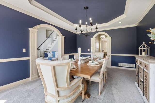 2570 Jewett Rd, Powell, OH 43065 - dining space featuring arched walkways, a raised ceiling, a chandelier, carpet flooring, and ornamental molding