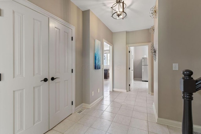 2570 Jewett Rd, Powell, OH 43065 - hallway featuring light tile patterned flooring and a chandelier