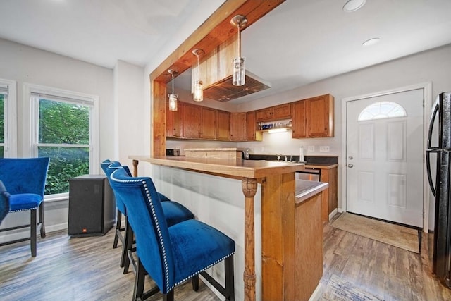 926 Harmon Ave, Columbus, OH 43223 - kitchen featuring brown cabinetry, freestanding refrigerator, light wood-style flooring, plenty of natural light, and recessed lighting