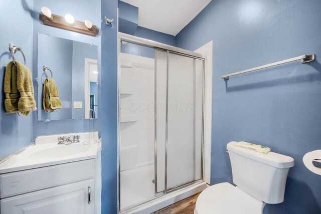 926 Harmon Ave, Columbus, OH 43223 - full bathroom featuring toilet, a shower stall, vanity, and wood finished floors