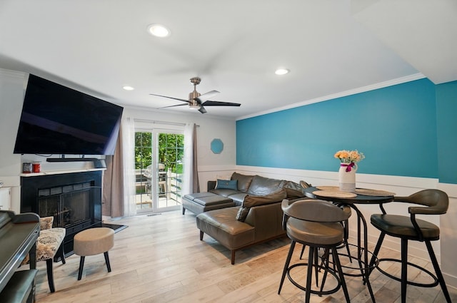 2201 Teardrop Ave Unit 34A, Columbus, OH 43235 - living room with crown molding, wainscoting, a fireplace, a ceiling fan, and wood finished floors