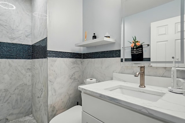 2201 Teardrop Ave Unit 34A, Columbus, OH 43235 - bathroom featuring vanity, tiled shower, toilet, and tile walls