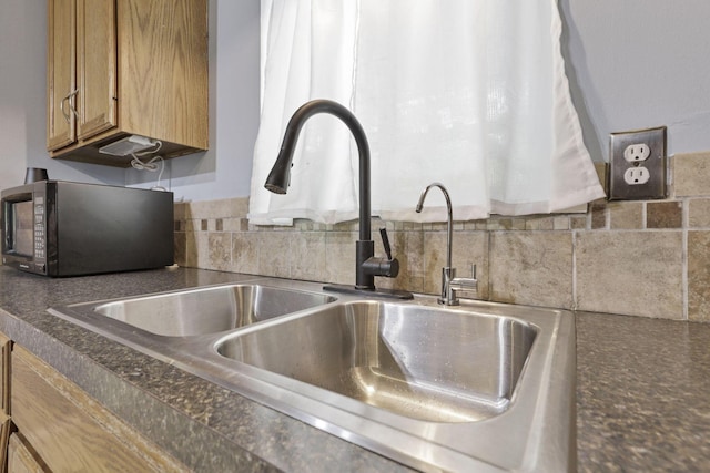 8175 Vore Ridge Rd, Athens, OH 45701 - kitchen view of black microwave, a sink, dark countertops, and decorative backsplash