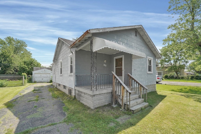 2007 Dunbar Dr, Columbus, OH 43224 - shotgun-style home featuring a front yard, asphalt driveway, and an outbuilding