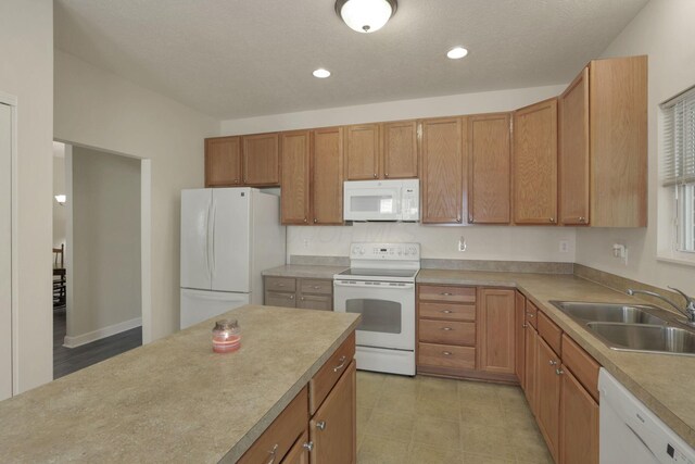 6370 Portrait Cir Unit 103, Westerville, OH 43081 - kitchen with white appliances, a sink, light countertops, recessed lighting, and brown cabinets