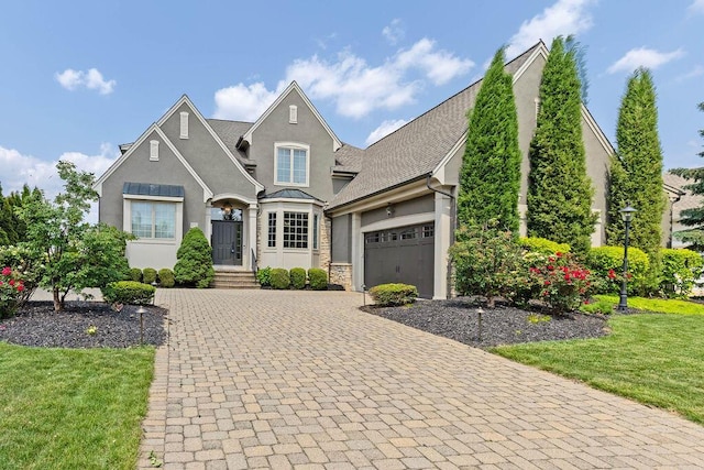 5753 Aster Way, Galena, OH 43021 - french country inspired facade with stucco siding, decorative driveway, an attached garage, a front yard, and a standing seam roof