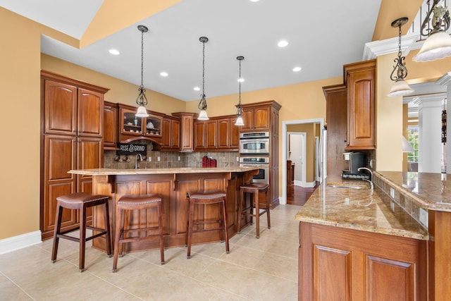 5753 Aster Way, Galena, OH 43021 - kitchen with a sink, decorative backsplash, light stone counters, brown cabinets, and light tile patterned flooring
