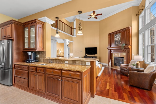 5753 Aster Way, Galena, OH 43021 - kitchen with freestanding refrigerator, open floor plan, a sink, brown cabinets, and ornamental molding
