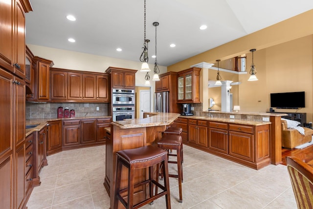 5753 Aster Way, Galena, OH 43021 - kitchen featuring appliances with stainless steel finishes, backsplash, glass insert cabinets, a peninsula, and light stone countertops