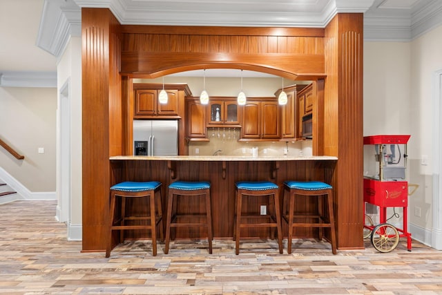 5753 Aster Way, Galena, OH 43021 - kitchen with built in fridge, brown cabinetry, light wood-type flooring, glass insert cabinets, and tasteful backsplash