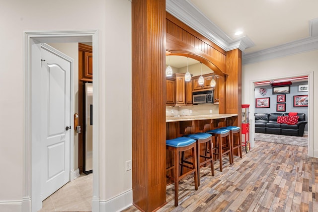 5753 Aster Way, Galena, OH 43021 - bar area featuring stainless steel appliances, ornamental molding, light wood-style floors, and baseboards
