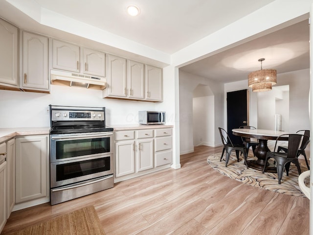 12609 Fancher Rd, Westerville, OH 43082 - kitchen featuring under cabinet range hood, appliances with stainless steel finishes, light countertops, light wood-style floors, and pendant lighting