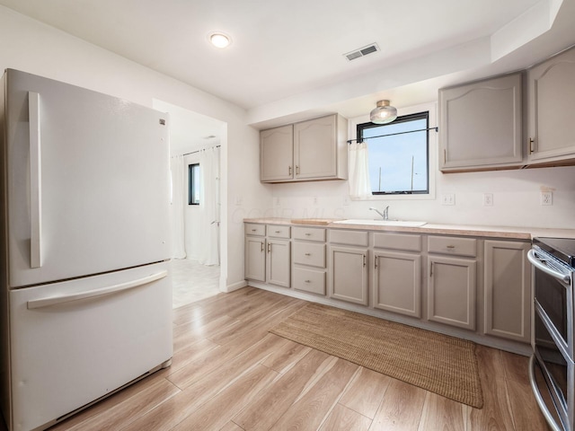 12609 Fancher Rd, Westerville, OH 43082 - kitchen with freestanding refrigerator, gray cabinetry, range with two ovens, light wood-type flooring, and light countertops