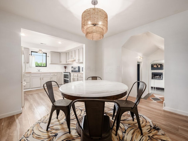 12609 Fancher Rd, Westerville, OH 43082 - dining area with a chandelier, light wood-style floors, a large fireplace, and recessed lighting