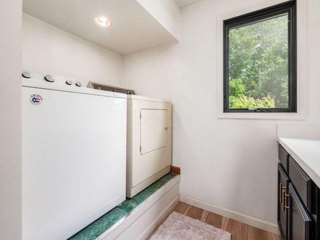 12609 Fancher Rd, Westerville, OH 43082 - washroom with separate washer and dryer, cabinet space, and light wood-style flooring