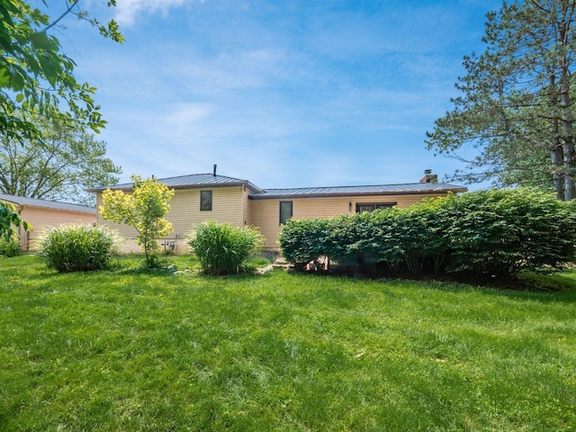 12609 Fancher Rd, Westerville, OH 43082 - view of front of home featuring a standing seam roof, a front yard, a chimney, and a metal roof