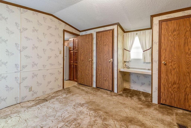 8764 National Rd SW Unit 118, Etna, OH 43062 - unfurnished bedroom featuring crown molding, freestanding refrigerator, carpet floors, wallpapered walls, and a textured ceiling