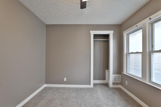 212-214 S Eureka Ave, Columbus, OH 43204 - unfurnished bedroom featuring baseboards, a textured ceiling, multiple windows, carpet floors, and a closet