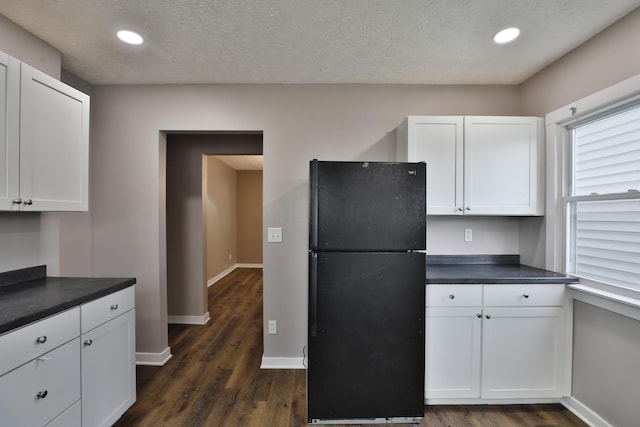 212-214 S Eureka Ave, Columbus, OH 43204 - kitchen featuring freestanding refrigerator, dark countertops, dark wood finished floors, white cabinets, and baseboards