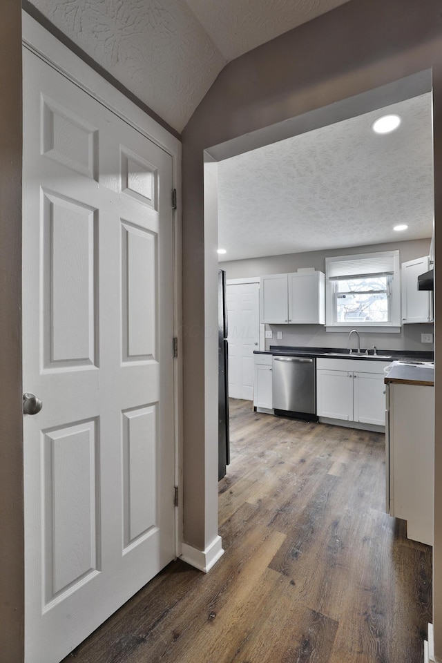 212-214 S Eureka Ave, Columbus, OH 43204 - kitchen featuring stainless steel dishwasher, dark countertops, white cabinetry, wood finished floors, and a textured ceiling