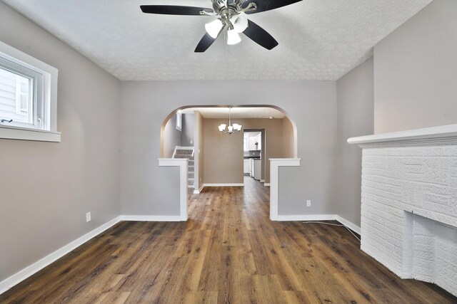 212-214 S Eureka Ave, Columbus, OH 43204 - unfurnished living room featuring arched walkways, wood finished floors, baseboards, a ceiling fan, and a chandelier