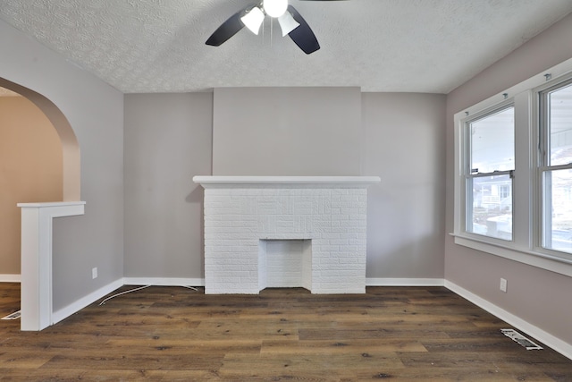 212-214 S Eureka Ave, Columbus, OH 43204 - unfurnished living room featuring a fireplace, a textured ceiling, a ceiling fan, wood finished floors, and baseboards