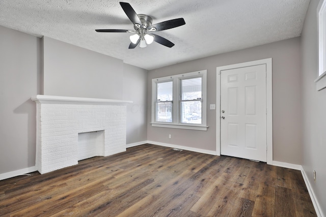 212-214 S Eureka Ave, Columbus, OH 43204 - unfurnished living room featuring dark wood finished floors, a ceiling fan, a textured ceiling, baseboards, and a fireplace