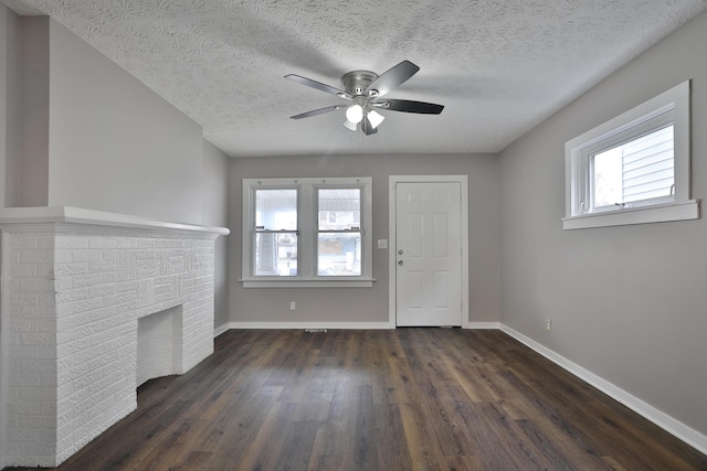 212-214 S Eureka Ave, Columbus, OH 43204 - unfurnished living room featuring dark wood finished floors, baseboards, healthy amount of natural light, ceiling fan, and a textured ceiling