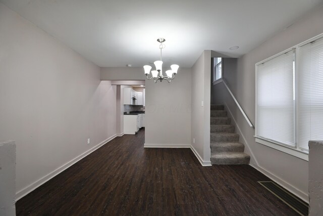212-214 S Eureka Ave, Columbus, OH 43204 - unfurnished dining area featuring dark wood-type flooring, baseboards, stairs, and a chandelier