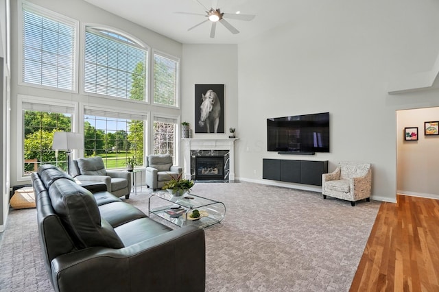 8073 Tree Lake Blvd, Powell, OH 43065 - living area featuring a towering ceiling, ceiling fan, a fireplace, and wood finished floors