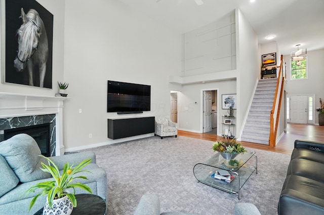 8073 Tree Lake Blvd, Powell, OH 43065 - living area featuring high vaulted ceiling, stairs, a premium fireplace, and wood finished floors