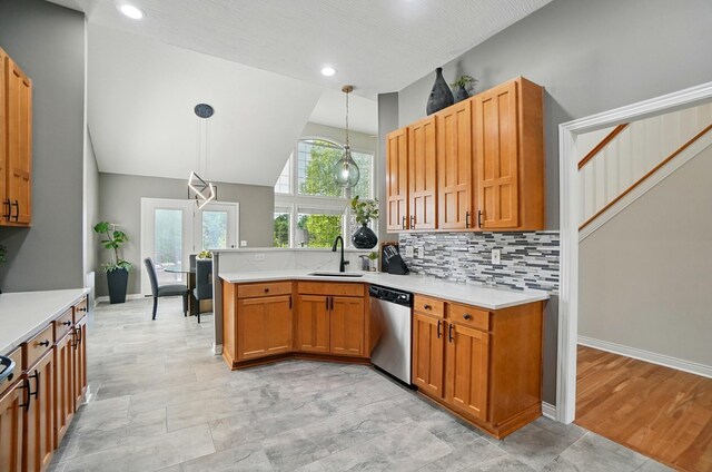 8073 Tree Lake Blvd, Powell, OH 43065 - kitchen featuring stainless steel dishwasher, a peninsula, light countertops, pendant lighting, and backsplash