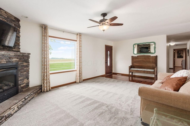 1875 Madden Higgins Rd, London, OH 43140 - living room featuring carpet flooring, ceiling fan, a stone fireplace, and baseboards