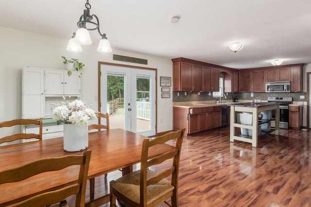 1875 Madden Higgins Rd, London, OH 43140 - kitchen featuring stainless steel appliances, decorative backsplash, dark wood-style flooring, and healthy amount of natural light