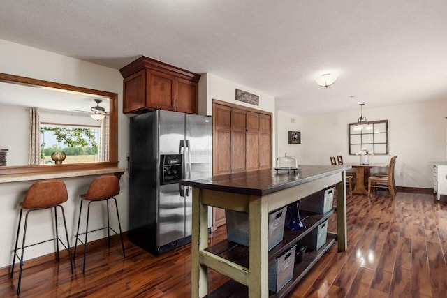 1875 Madden Higgins Rd, London, OH 43140 - kitchen with stainless steel fridge, dark wood-type flooring, baseboards, a kitchen breakfast bar, and decorative light fixtures