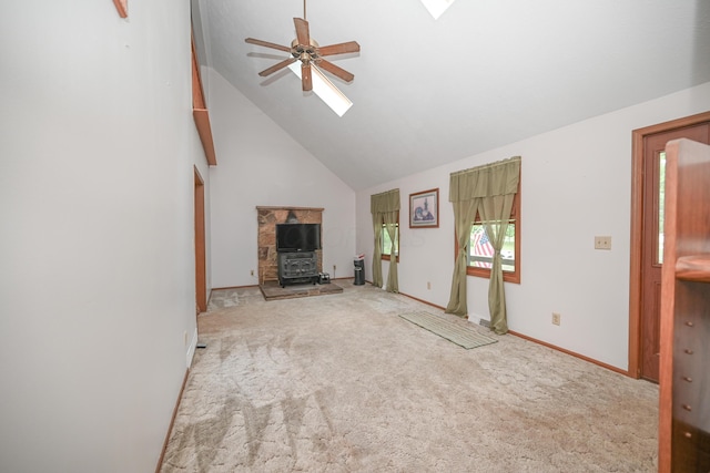 5467 Timpson Rd, Caledonia, OH 43314 - unfurnished living room with a skylight, high vaulted ceiling, a wood stove, a ceiling fan, and carpet floors