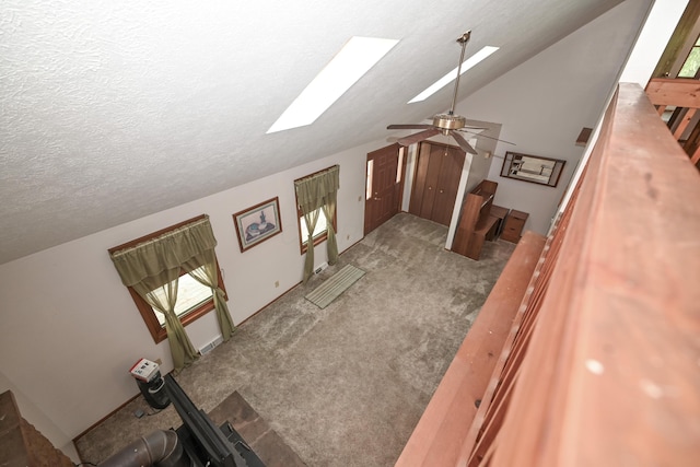 5467 Timpson Rd, Caledonia, OH 43314 - unfurnished living room featuring a skylight, a textured ceiling, lofted ceiling, carpet floors, and ceiling fan