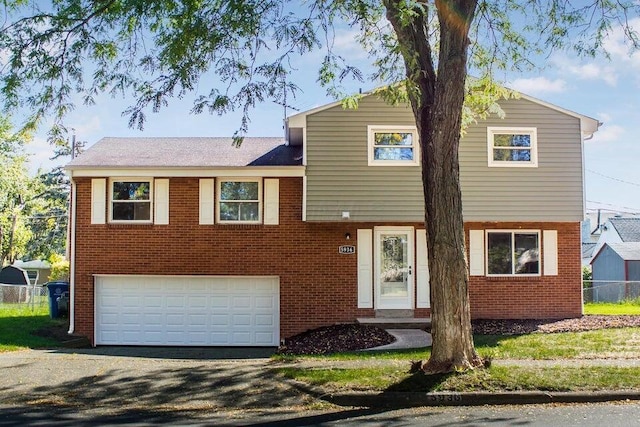 5936 Endicott Rd, Columbus, OH 43229 - split level home with brick siding, a garage, and asphalt driveway