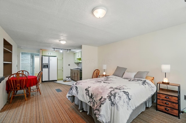 5350 Brook Rd NW, Lancaster, OH 43130 - bedroom featuring white fridge with ice dispenser, light colored carpet, a textured ceiling, rail lighting, and a sink