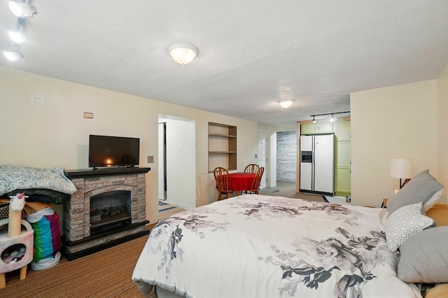 5350 Brook Rd NW, Lancaster, OH 43130 - bedroom featuring white refrigerator with ice dispenser, a textured ceiling, and a fireplace