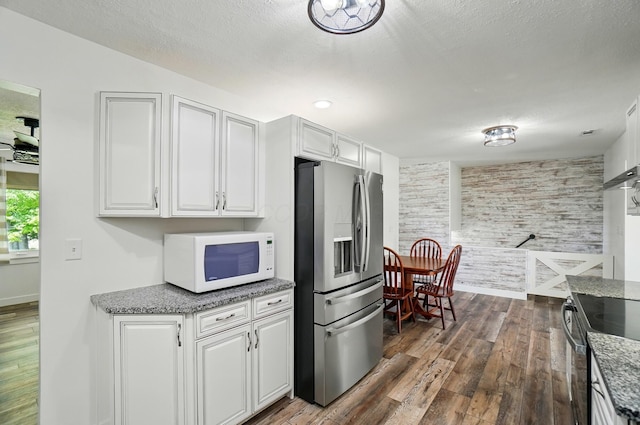 5350 Brook Rd NW, Lancaster, OH 43130 - kitchen featuring appliances with stainless steel finishes, dark wood finished floors, white cabinets, stone counters, and a textured ceiling