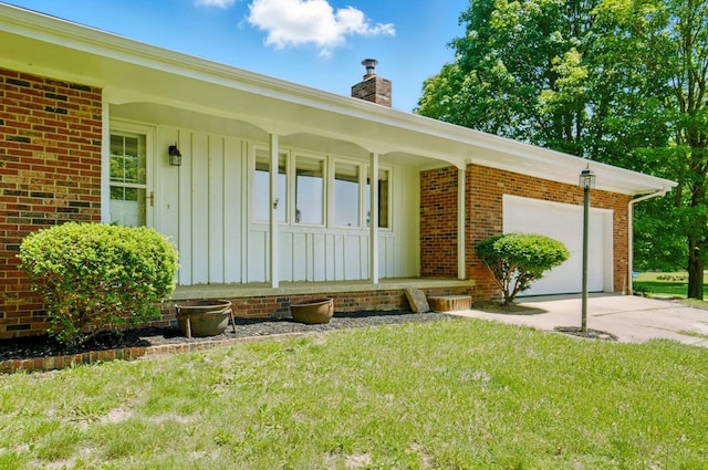 5350 Brook Rd NW, Lancaster, OH 43130 - property entrance with a chimney, a porch, driveway, an attached garage, and board and batten siding