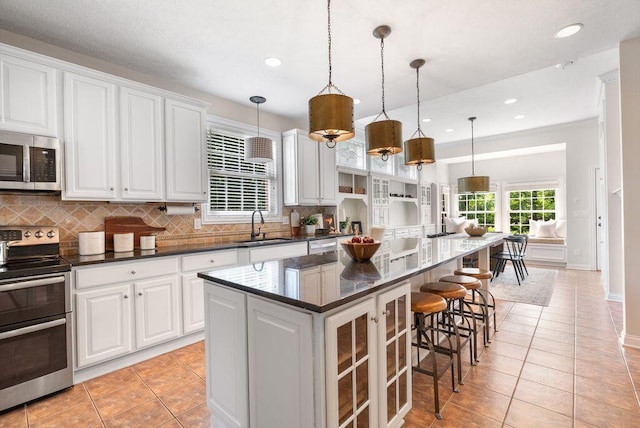 8467 Tartan Fields Dr, Dublin, OH 43017 - kitchen with appliances with stainless steel finishes, light tile patterned flooring, a sink, decorative backsplash, and recessed lighting